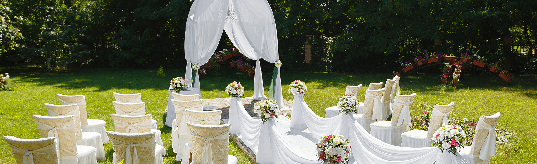 Outdoor wedding ceremony seating with floral arch