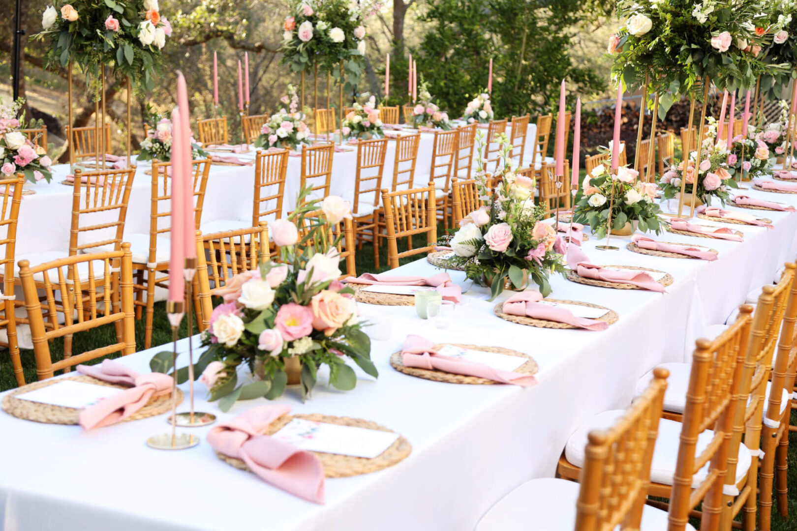 Outdoor wedding reception with pink floral centerpieces